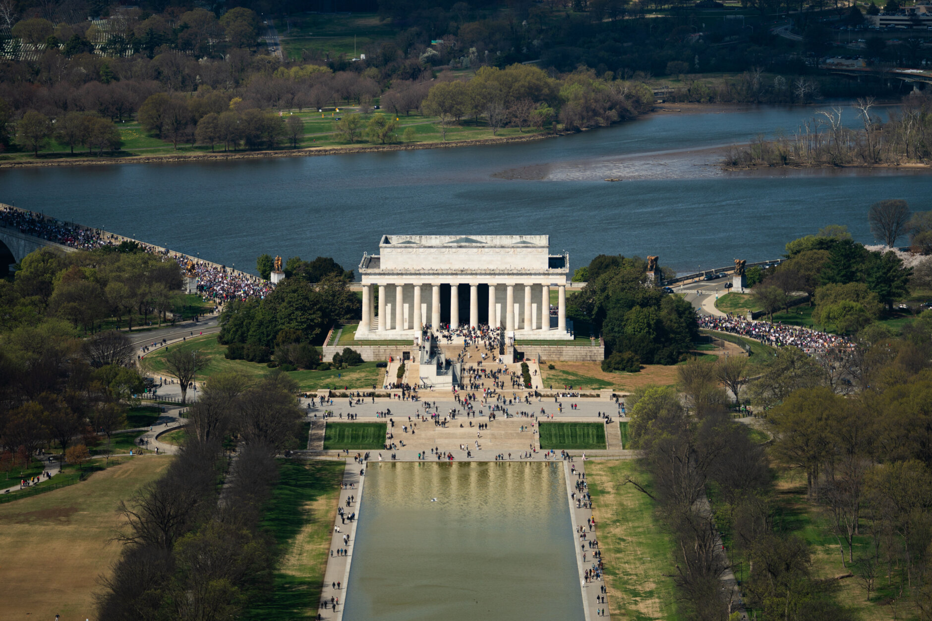 Demonstrators march across Memorial Bridge and around the Lincoln Memorial during the No Kings protest in Washington, Saturday, March 28, 2026. (AP Photo/Allison Robbert)