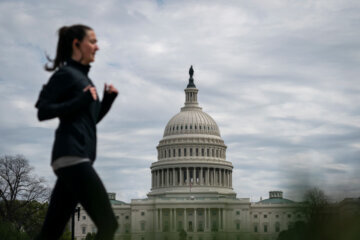 WASHINGTON, DC - APRIL 14: A jogger runs on the National Mall with the U.S. Capitol in the background on April 14, 2020 in Washington, DC. Last week, Events DC, the official convention and sports authority for Washington, DC approved an $18 million relief package to help bolster the hospitality and tourism industry in the nation's capital. (Photo by Drew Angerer/Getty Images)