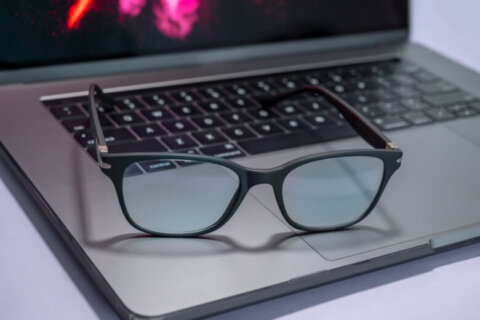 Blue light blocking glasses on the laptop. Black frame glasses for filtering blue light from the computer. Prevent Computer Vision Syndrome. Eye protection from PC screen