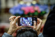 NEW YORK, NY - APRIL 21: A person take a photo next to A picture of Pope Francis is displayed as people gather at St. Patricks Cathedral to pay respects to Pope Francis on April 21, 2025 in New York City. The Vatican announced that Pope Francis, 88, died on Monday at 07:35 local time (05:35 GMT) and the Bishop of Rome, Francis, returned to the home of the Father. His death comes after he appeared in St Peter's Square on Easter Sunday, greeting thousands of worshippers. His body will be transferred to St Peter's basilica on Wednesday morning to allow members of the public to pay their respects. (Photo by Kena Betancur/VIEWpress/Getty Images)