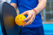 person ready to hit a pickleball face not shown