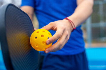 person ready to hit a pickleball face not shown