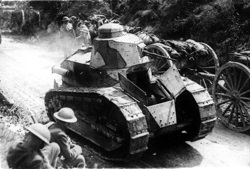 Two soldiers are passed by tanks