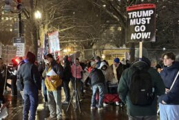 'Trump must go now' sign held by protester outside the White House, on Monday, March 2, 2026.