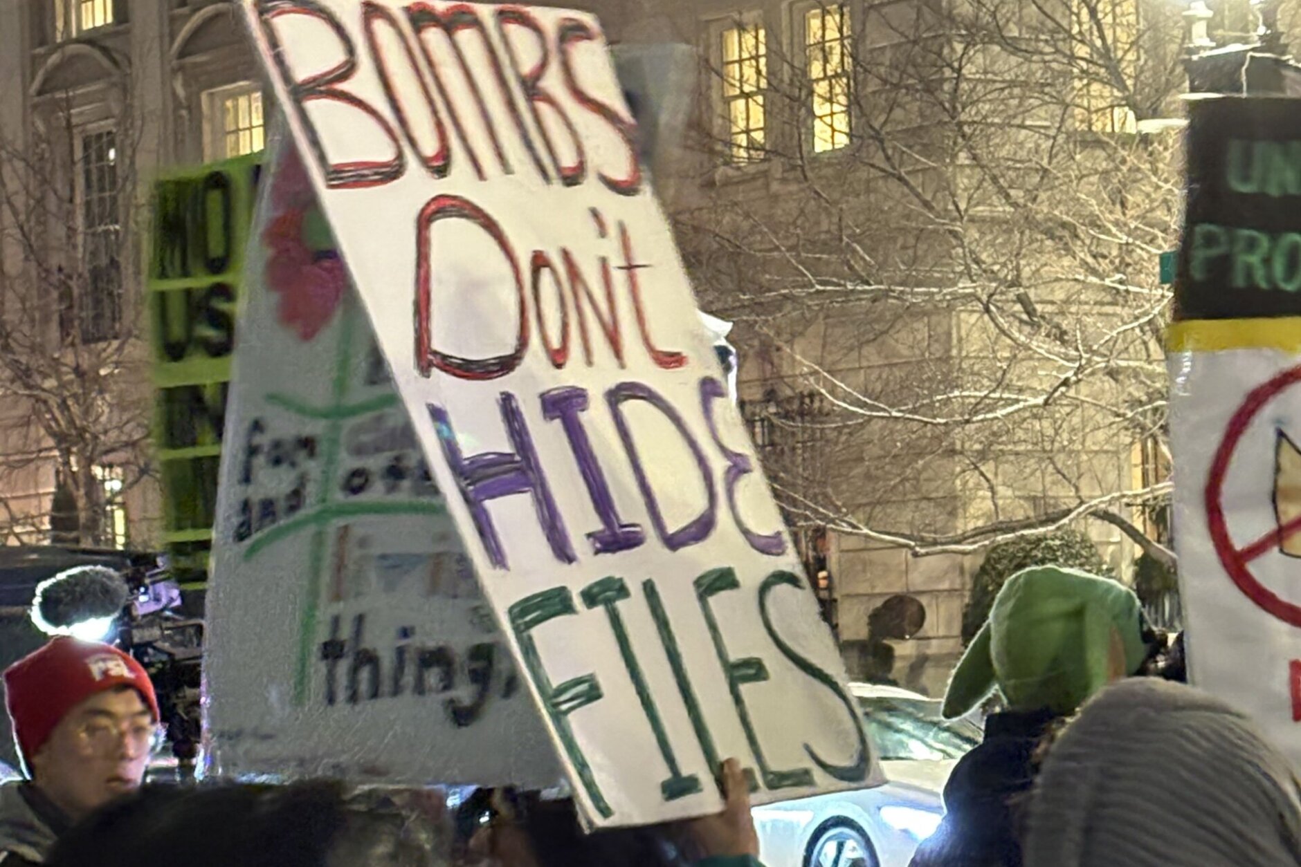 'Bombs don't hide files' sign held by protester outside the White House, on Monday, March 2, 2026.