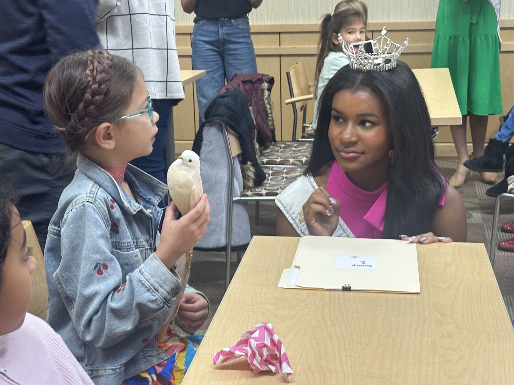 miss teen maryland listens to a young child at a workshop
