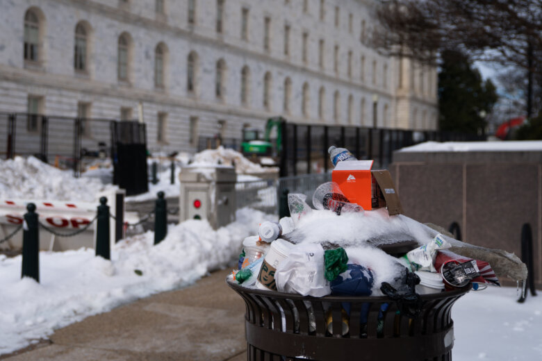 An overfilled trash can, Jan. 26, 2026, in Washington. There is no trash collection on Monday, Jan. 26, 2026 due to the snow. (AP Photo/Allison Robbert)