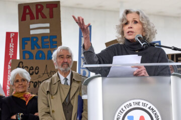 Jane Fonda, right, along with singer Joan Baez, left, and actor Sam Waterston, center, speaks during a rally of, "Artists United for our Freedoms," near the Kennedy Center, Friday, March 27, 2026, in Washington. (AP Photo/Jacquelyn Martin)