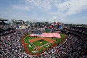 An American flag is held across the field during the national anthem