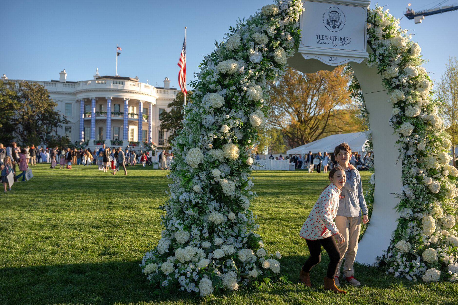 Children walk through a floral arch during the White House Easter Egg Roll