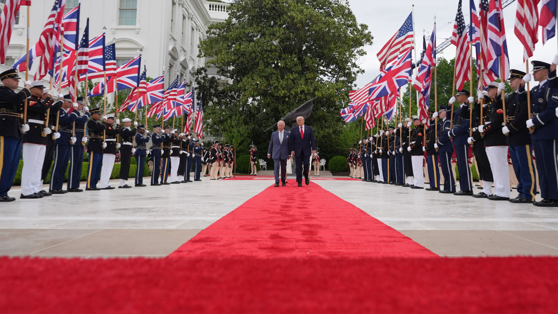 President Donald Trump walks on the red carpet in the Rose Garden with Britain's King Charles III, Queen Camilla and first lady Melania Trump