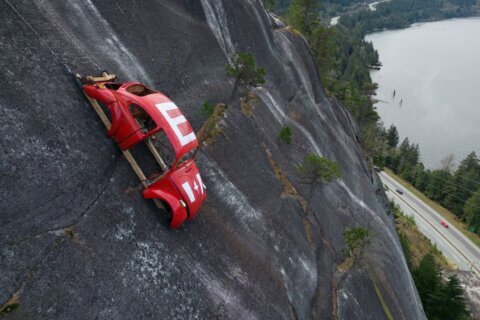 Car shell suspended on rock face above British Columbia highway in apparent prank