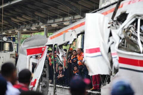 Rescuers trying to reach 3 people trapped in damaged train car after crash in Indonesia