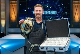 brian holds up a belt and prize money