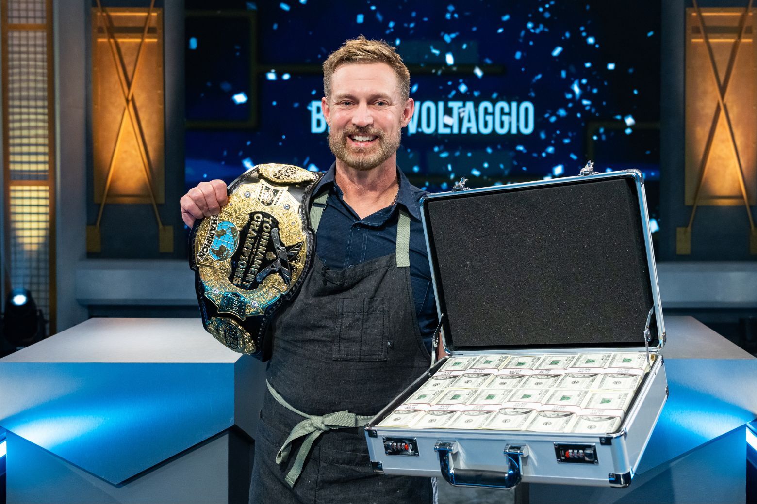 brian holds up a belt and prize money