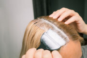 Woman dyeing her hair in front of mirror