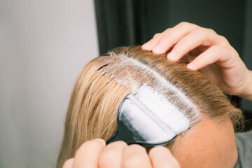 Woman dyeing her hair in front of mirror