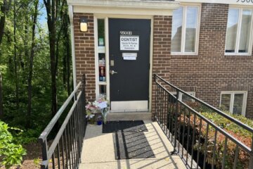 outside of a dental practice with flowers laying at the door