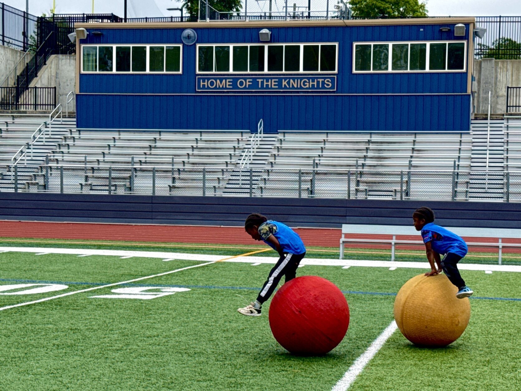 students running a drill with large colorful balls