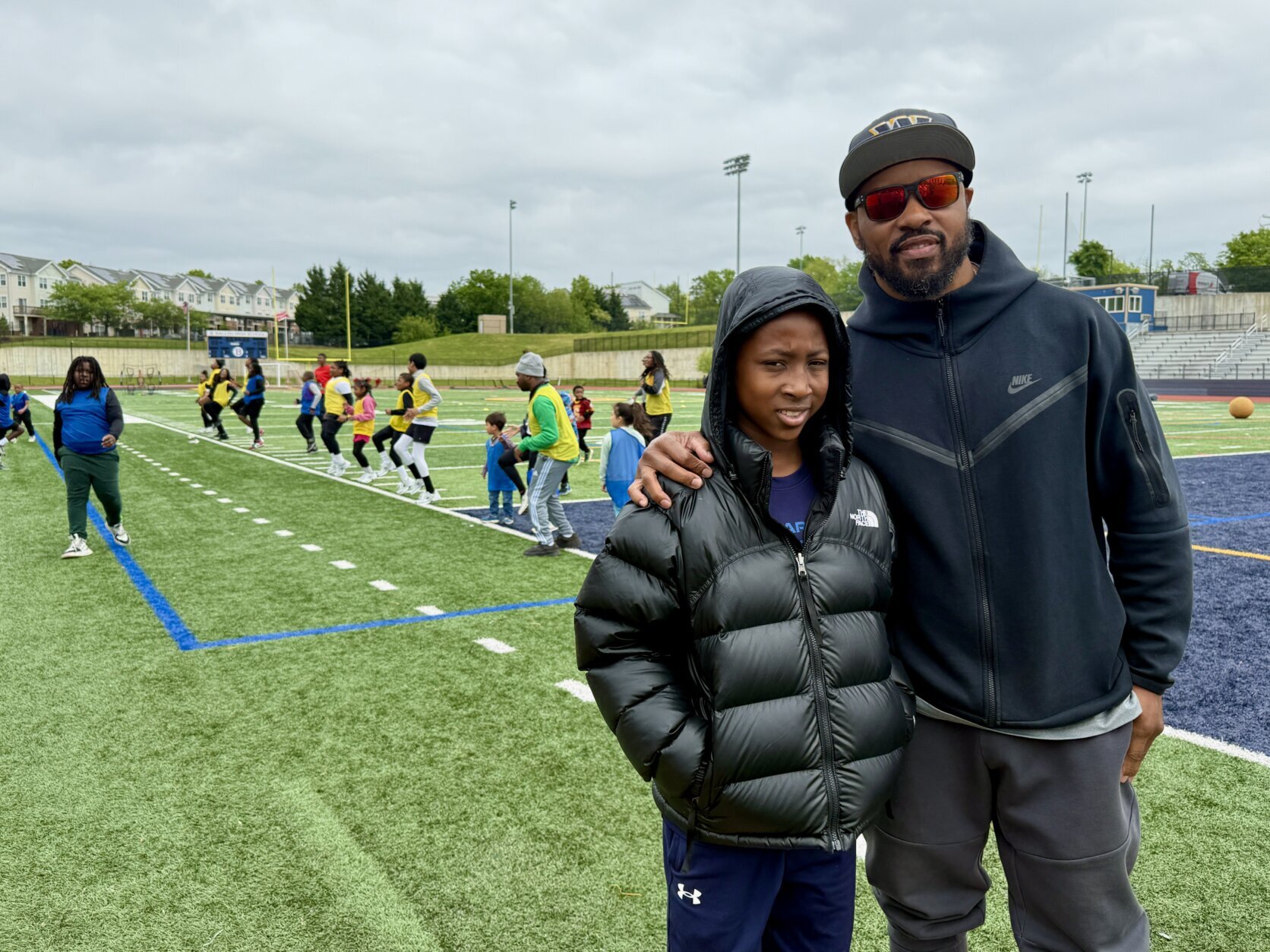 Santana Moss with a student at football clinic