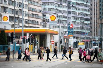 Pedestrians walk through a zebra crossing in front of the gas stations logos from the energy and petrochemical company, Shell Oil Company, and Asian-Pacific gas and oil company Caltex  in Hong Kong, on March 9, 2026