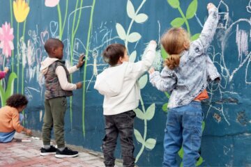 Kids are playing with chalk outside.