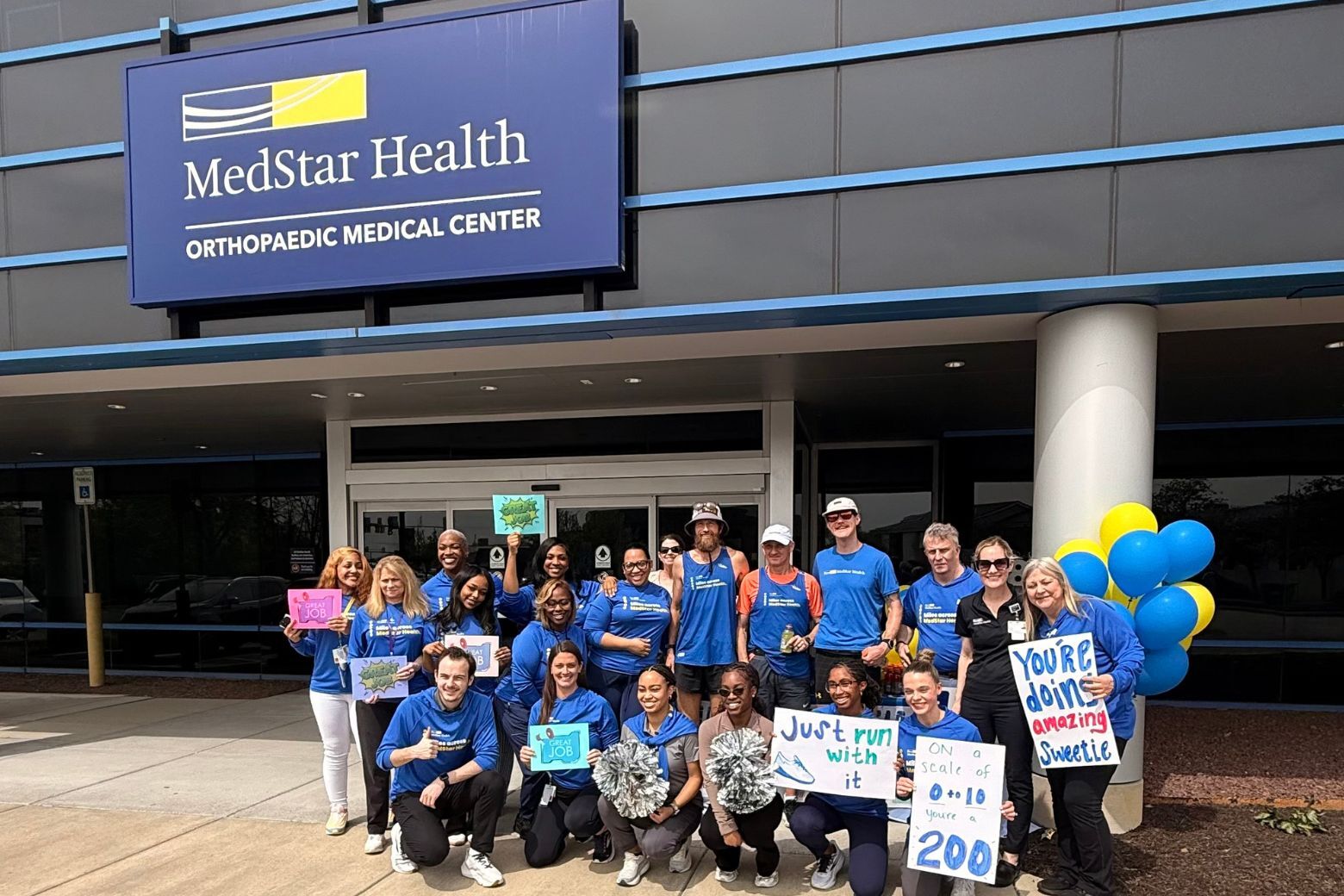 a crowd with signs cheering on the runners