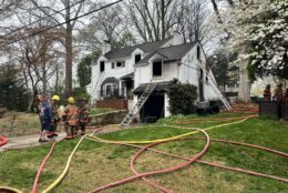 firefighters outside house with hoses after fire