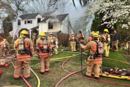 firefighters outside of house responding to fire, smoke coming from home