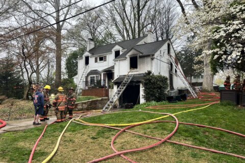firefighters outside house with hoses after fire