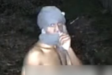 a person shirtless with clothing wrapped around head and face on surveillance footage