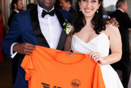 Brittany Keroack, 32, and Shank Subramani, in wedding attire holding up a Volo t-shirt
