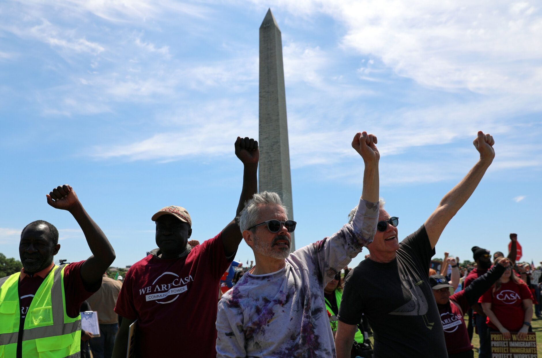 Demonstrators march as they rally at the National Mall during a May Day protest Friday, May 1, 2026, in Washington. The Washington Monument is in the background, (AP Photo/Rahmat Gul)