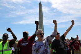 Demonstrators march as they rally at the National Mall during a May Day protest Friday, May 1, 2026, in Washington. The Washington Monument is in the background, (AP Photo/Rahmat Gul)