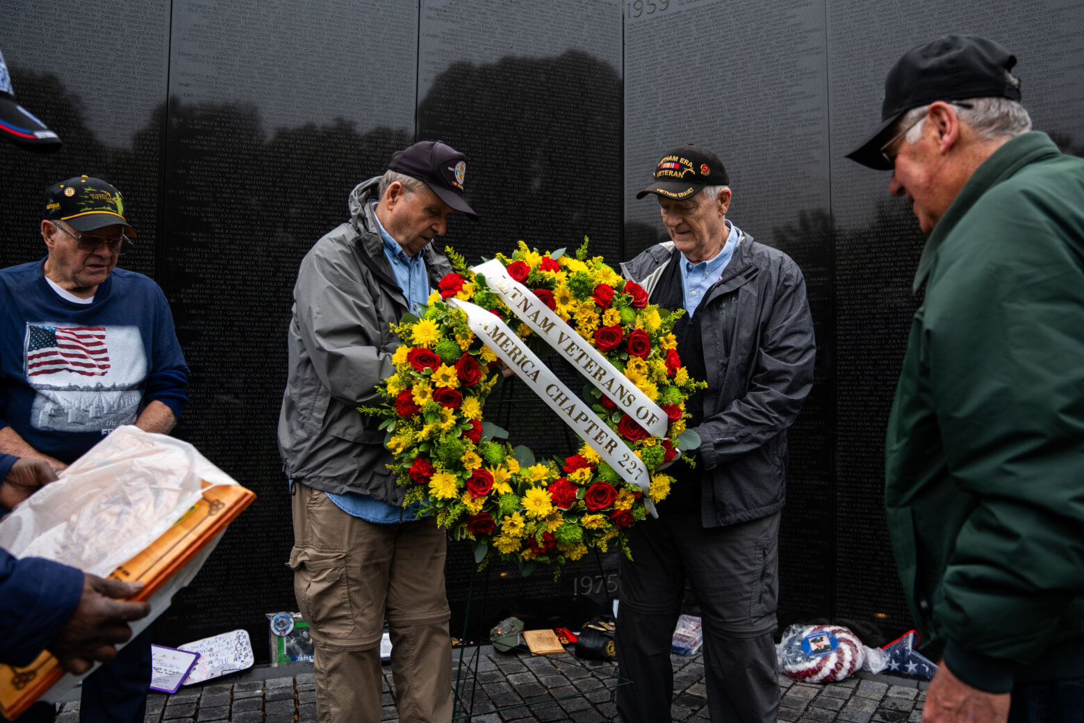 A local veterans group pays respects with a commemorative wreath at the Vietnam Veterans Memorial