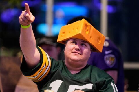 The cheesehead hat is a sunny nod to America’s ‘Hold my beer’ exuberance
