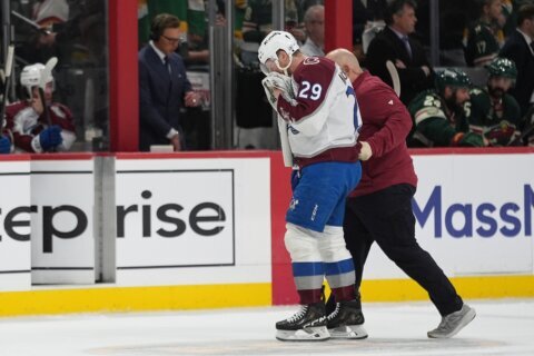 MacKinnon takes a puck from an Avs teammate to the face