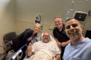 Dr. Ehsan Jazini (right), Randy Sutton (second from right and Texas sheriff’s deputy Tim Putney (in bed) and his wife Chelsea before surgery in Reston.

