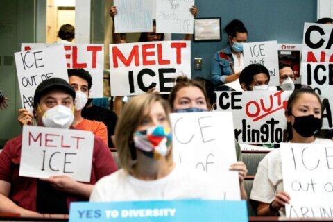 Demonstrators with La ColectiVA protest during the Arlington County Board meeting