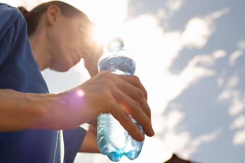 Woman drinking water in extreme summer heat wave