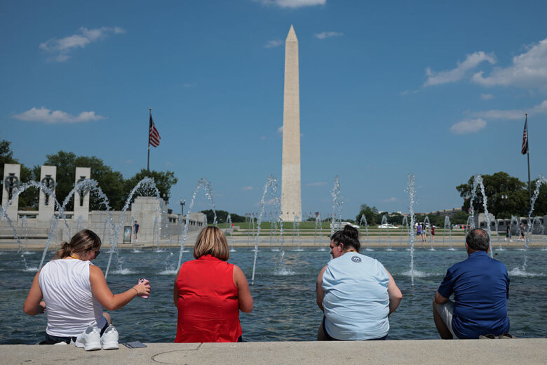 Visitors dip their feet into the World War II Memorial pool