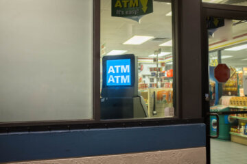 ATM machine is seen through the store window.