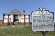 old school building with a sign in the foreground