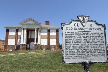 old school building with a sign in the foreground