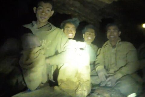Rescuers evacuate the first of 5 villagers found trapped in a cave in Laos; 2 still missing