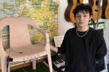 person stands next to monobloc chair converted into an instrument with harp strings