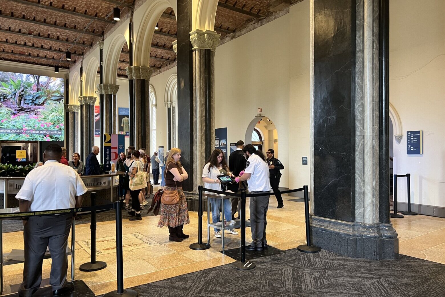 people go through security lines inside museum