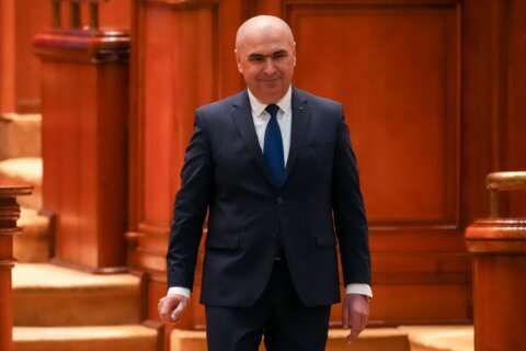 Romania’s prime minister fights for survival as no-confidence motion is debated in Parliament