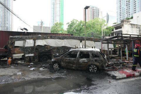 A cargo train hits a public bus at a Bangkok rail crossing, killing at least 8