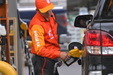 An employee of a gas station supplies fuel to a vehicle in the north of Quito, on March 12, 2026.